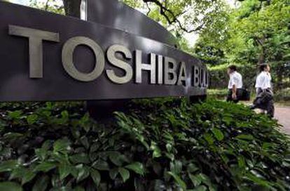 Dos hombres caminan frente a la sede de la empresa japonesa de electrónica Toshiba en Tokio, Japón. EFE/Archivo