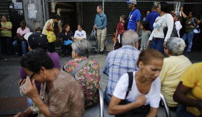 Venezolanos esperan en la entrada de un supermercado de Caracas, Venezuela, el 23 de agosto.