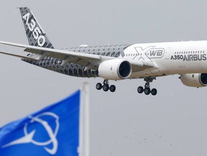 Imagen de un Airbus A350 volando sobre una bandera de Boeing, en una feria en París. 