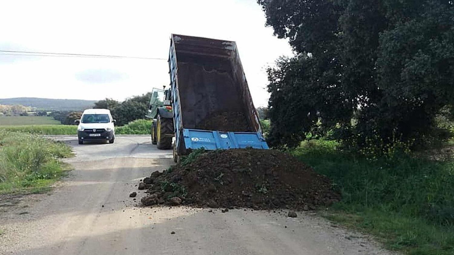 Un camión vuelca arena para cerrar uno de los accesos de Setenil de las Bodegas (Cádiz).