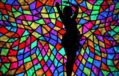 Una mujer baila delante de una escultura iluminada llamada Crystallize, que forma parte del 'Festival Vivid Sydney' de la luz y del sonido, en Sídney (Australia).