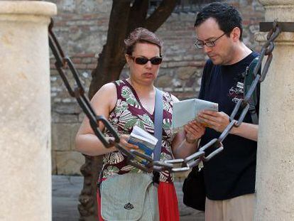 Dos turistas consultan su plano cerca de la catedral de Málaga.