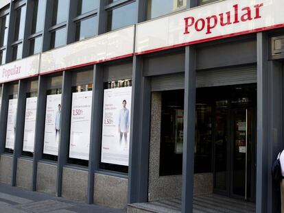 Un hombre sacando dinero de un cajero de Popular