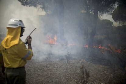 Un técnico del Infoca avisa por radio a uno de los retenes en el incendio forestal.