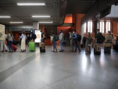 Viajeros en la estación de Atocha, a las 15.00 horas, cuando el Gobierno ya había anunciado el estado de alarma en Madrid y preparaba su entrada en vigor.