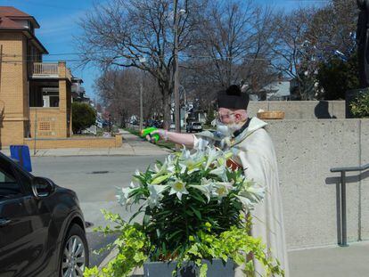 El sacerdote Timothy Pelc disparando agua bendita al coche de un feligrés en Míchigan.