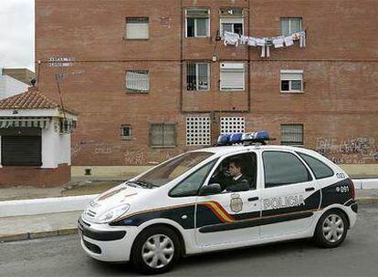 Un coche de la Policía pasa por donde fue apuñalada la joven, en la barriada Rabesa de Alcala de Guadaira.