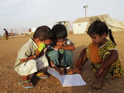 Unos niños observan un cuaderno escolar en el campo de refugiados de Marzaki (Yibuti).