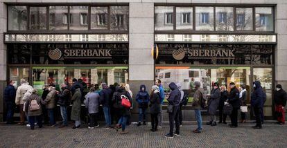 Un grupo de gente haciendo cola para entrar en una sucursal del banco público ruso, Sberbank.