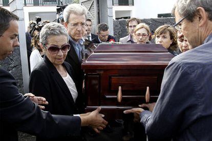 La hija de Saramago, Violante, con gafas a la izquierda; y su mujer Pilar del Río, al fondo con gafas de montura roja, portan el féretro del Nobel antes de su traslado hacia Lisboa.