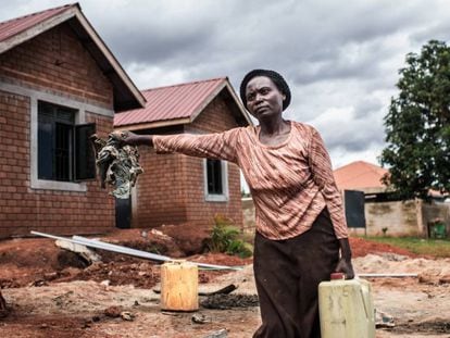 Betty Nakiberu, una de las cooperativistas, frente a su vivienda durante la construcción.