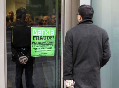 Un cliente espera poder entrar en la sucursal de Bankia de la Gran Vía de Madrid que ha sido ocupada por un grupo de afectados por las preferentes.