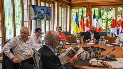 En primer plano, Joe Biden lee un periódico al inicio de la reunión este lunes con el resto de dirigentes del G-7, en el castillo de Elmau, Alemania.