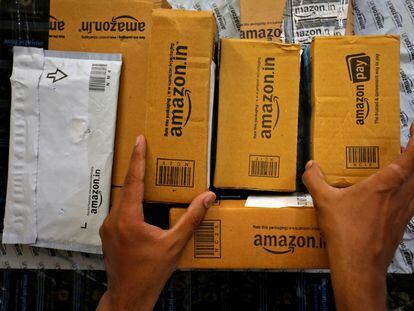 Un empleado de Amazon selecciona paquetes en una furgoneta en Ahmedabad (India), en marzo.