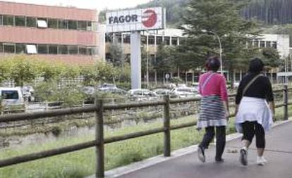 Dos mujeres caminan junto a la factoría de la empresa Fagor en la localidad guipuzcoana de Mondragón. EFE/Archivo