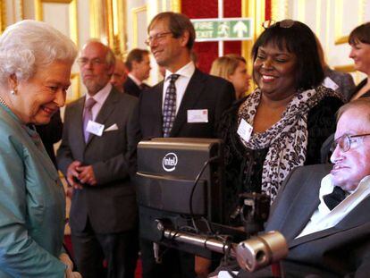 Stephen Hawking junto a su enfermera, Patricia Dowdy, durante una visita a Isabel II en el Palacio de Buckingham en 2014.