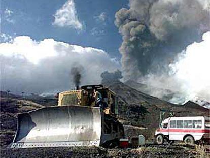 Una excavadora levanta una barrera para evitar que la lava del Etna llegue a la población de Nicolosi (Sicilia).