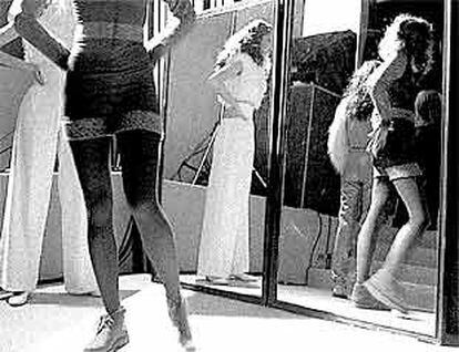 Unas modelos se preparan en el vestuario para salir a la pasarela durante un desfile de moda.