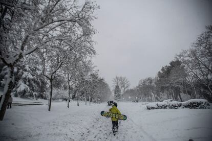 Un joven con una tabla de 'snow', en el parque del Paraíso de Madrid durante el temporal 'Filomena'.