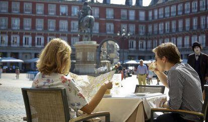 Una pareja de turistas, en una terraza de la plaza Mayor.