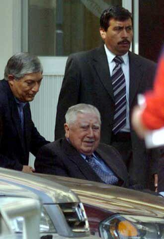 Augusto Pinochet, ayudado por sus guardaespaldas en 2004.