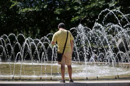Un hombre se acerca a una fuente en un parque de Madrid, este martes.