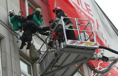 Los Bomberos retiran una pancarta colocada por activistas de Greenpeace en la fachada del Ministerio de Economía en Varsovia (Polonia), hoy.