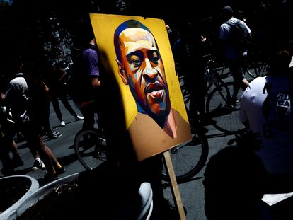 Un manifestante sostiene una imagen con el rostro de George Floyd, el afroamericano asesinado por un policía blanco en Nueva York.