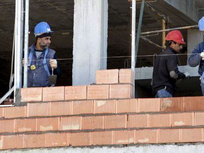 Tres obreros trabajan en la construcci&oacute;n de una vivienda. EFE/Archivo