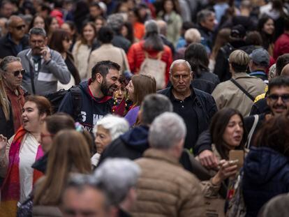 Dos personas se sonríen entre la multitud viandantes, en la Rambla de Barcelona, este martes durante el día de Sant Jordi.