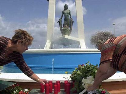 Dos mujeres colocan velas y flores en el monumento dedicado a Rocío Jurado de Chipiona.