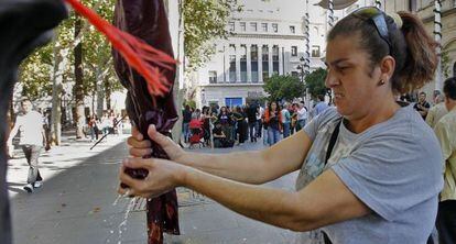 Una de las ocupantes de la Corrala La Utopía hace la colada frente al Ayuntamiento como protesta.