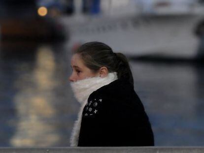 Una jove es protegeix del fred a Barcelona.
