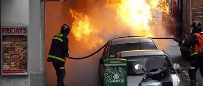 Los bomberos de Madrid apagan un incendio de un vehículo en Gran Vía.