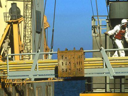 Un trabajador cruza una pasarela en una plataforma petrol&iacute;fera de Aramco, en el Golfo P&eacute;rsico. 