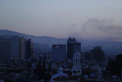 Columnas de humo salen de varios edificios de la capital de Siria tras los bombardeos.