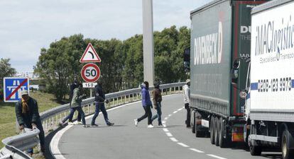 Varios inmigrantes cruzan una v&iacute;a cerca de la entrada del eurot&uacute;nel.