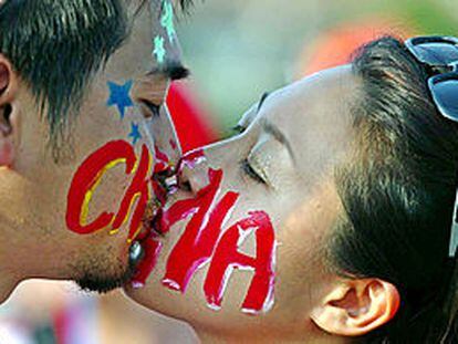 Mundial 2002, Brasil-China: dos aficionados chinos con las caras pintadas se besan antes del encuentro. PRIMER PLANO - ESCENA