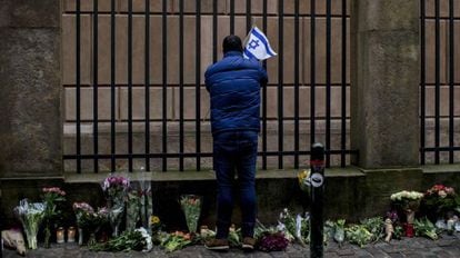 Un hombre pone una bandera israelí en la sinagoga de Copenhague.