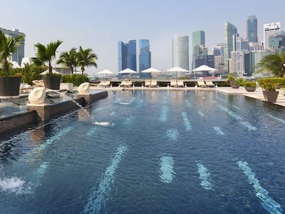 La piscina de 25 metros del hotel Mandarin Oriental Singapur, rodeada de un frondoso paisaje tropical.