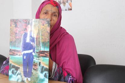 La madre de un joven tunecino desaparecido en el Mediterráneo muestra su fotografía.
