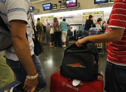 Pasajeros de Spanair, ayer frente a los mostradores de facturación de Barajas.