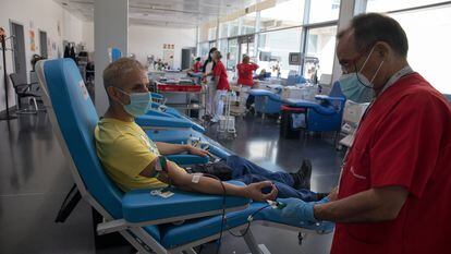 Un miembro del personal sanitario le extrae sangre a un hombre en el Centro de Transfusión de la Comunidad de Madrid.
