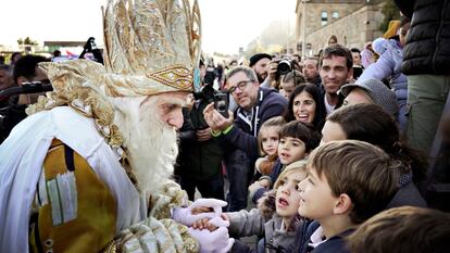 El Rey Melchor saluda a los niños que han acudido a recibirle en el puerto de Barcelona antes de la cabalgata.