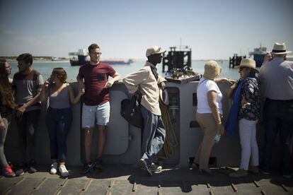 Entre las personas que cruzan en barco, un chico subsahariano aprovecha para intentar vender gafas de sol.