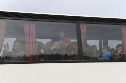 Los refugiados y los inmigrantes avandonan el campomento en autobús, durante la operación policial en Idomeni.