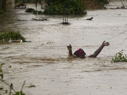 Una mujer avanza por una calle inundada en Puerto Príncipe.