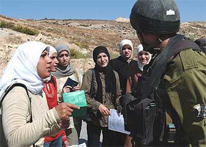 Un soldado examina la documentación de varias mujeres palestinas en las afueras de Ramala.