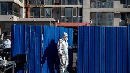 Un trabajador con equipo de protección en un barrio bajo confinamiento, el lunes en Pekín.