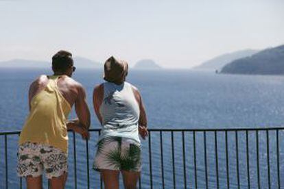 Dos turistas contemplando el mar en la isla griega de Skiathos.
